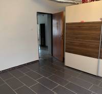 Interior of a family house with tiled flooring and a built-in wardrobe with a wooden decor.