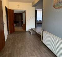 A hallway in a family house with a wooden decor floor and wooden doors.