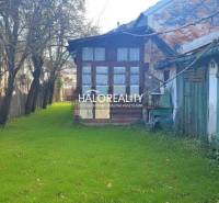 A garden at a family house in Rimavská Sobota with shady trees and grassy vegetation.