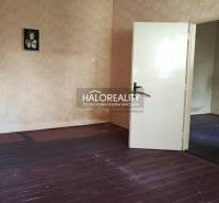 A room in a family house with a wooden decor floor and wallpaper.