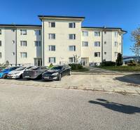 Železničná Street in Trenčianska Turná with parked cars in front of the apartment building.