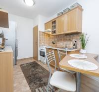 A kitchen in a 2-room apartment with wooden decor and appliances on the counter.