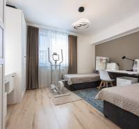 Children's room in a two-room apartment with two beds, a table, and an exercise machine.