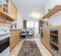 A kitchen in a 2-room apartment with a wooden decor and a dining area.