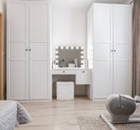 A bright room in a 2-room apartment with a vanity table, white wardrobes, and an exercise machine.