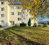 An apartment building in Trenčianska Turná on Železničná Street surrounded by greenery and trees.