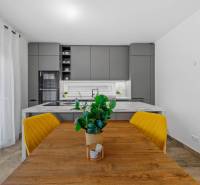 A family house kitchen with a dining table, yellow chairs, and a wooden decor floor.