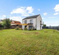 A family house on Breitensee Street in Marchegg with a well-maintained lawn and a wooden shelter.