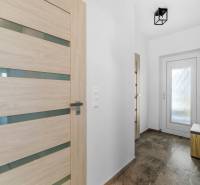 Entrance hallway in a family house with laminate and glass doors.