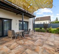 The terrace of a family house on Breitensee Street in Marchegg with a tiled floor and seating area.