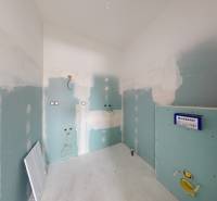 A construction room prepared for the installation of bathroom equipment in a family house.