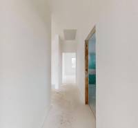 A hallway in a family house with light walls and a concrete floor.