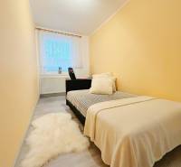 Cozy bedroom with a bed, carpet, and window in a family house.