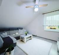 Living room in a family house with a corner sofa and a white carpet.