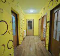 A hallway in a family house with colorful walls and a wooden decor floor.
