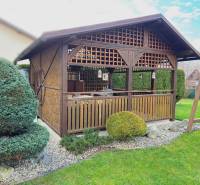 The garden of a family house in Kysucké Nové Mesto with a wooden gazebo and well-maintained lawn.