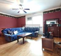 Living room with a corner sofa in a 4-room apartment, with a floor featuring a wooden decor.