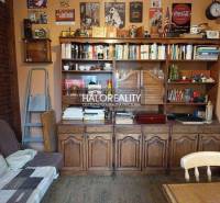 Living room with an antique wooden cabinet, books, and decorations in a four-room apartment.