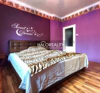 Purple bedroom with a bed and wood-decor flooring in a 4-room apartment.