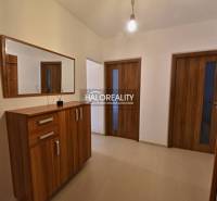 A hallway in a 2-room apartment with a wooden decor on the doors and cabinet, mirror on the wall.
