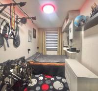 A room in a 3-room apartment with decorations, a bicycle, and shelves.