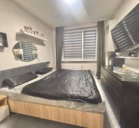 A bedroom in a 3-room apartment with a bed, wardrobes, and decorative accessories.