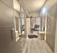 A hallway with a wooden decor floor in a 3-room apartment leading to the dining room.
