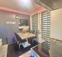 Kitchen in a 3-room apartment with a dining table, television, and the word 