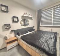 Bedroom in a 3-room apartment, double bed, nightstand, wall decorations.