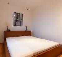 Bedroom with a bed and a decorative picture, wooden decor flooring, studio apartment.