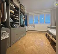 A room with a wooden floor decor, a wardrobe, and a children's bed.