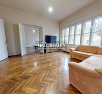Living room of a three-room apartment with a sofa and a wooden decor floor.