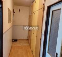 A narrow hallway with built-in wardrobes and a wood-patterned floor in a three-room apartment.