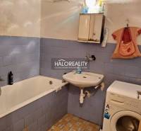 Bathroom in a 3-room apartment with a bathtub, sink, and washing machine, blue tiles.