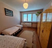 A bedroom with two beds and a wooden decor floor in a three-room apartment.