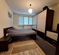 Bedroom in a 3-room apartment with a dresser, bed, and floor with wood decor.