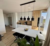 A kitchen in a 3-room apartment with a wooden decor floor and elegant lighting.
