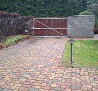 Outdoor paving and gate in a family house in Bohdanovce nad Trnavou, surrounded by greenery and trees.