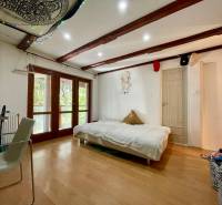 Interior of a cabin with a bed, chair, and floor with wooden decor.