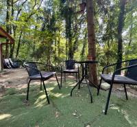 A cottage in Kučišdorská Valley, Pezinok, with outdoor seating surrounded by forests.