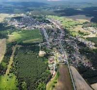 Aerial view of agricultural and forest land in Studienka with visible buildings and forests.