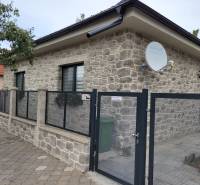 The family house in Okoličná na Ostrove has a stone facade and a satellite dish.