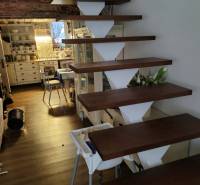 Interior of a family house with floating stairs, a kitchen, and a floor with a wood decor.