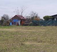 Grassy plot with wooden and brick structures on Recreational lands in Drahovce.