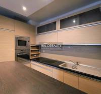 A kitchen in a 2-room apartment with a wooden decor floor and built-in appliances.