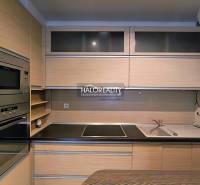 A kitchen in a 2-room apartment with wooden cabinets and built-in appliances.