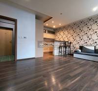 Interior of a 2-room apartment with a wooden decor floor and patterned wallpaper on the wall.