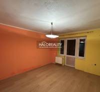A room in a 2-room apartment with orange-yellow walls and a wooden decor floor.