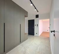 Entrance hallway of a 3-room apartment with a large wardrobe and tiles with a natural pattern.