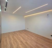 Interior of a 3-room apartment with white walls and a floor with a wood decor, lighting.